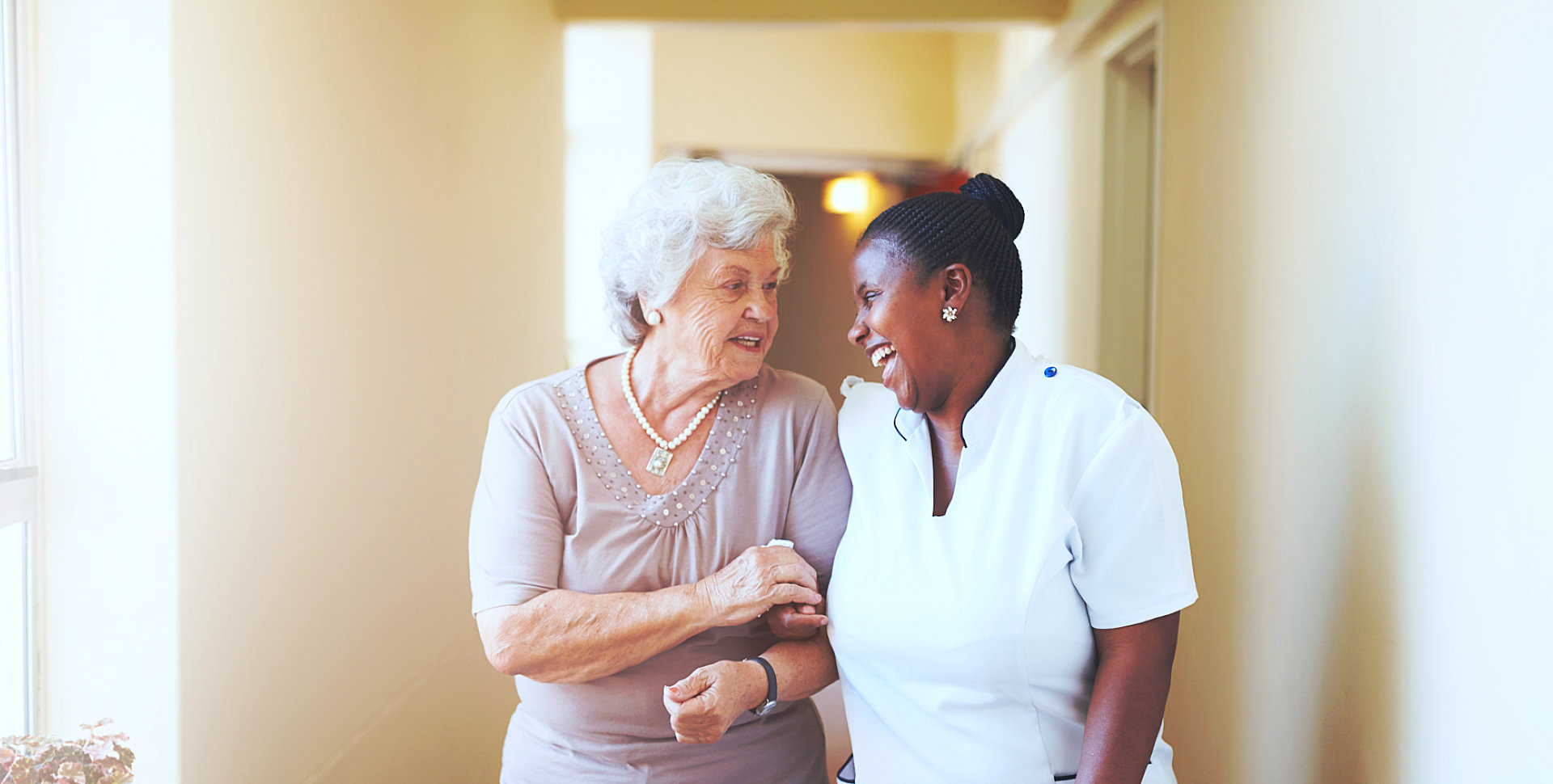 young caregiver and old woman smiling