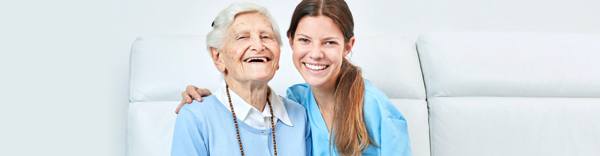 young caregiver and old woman smiling